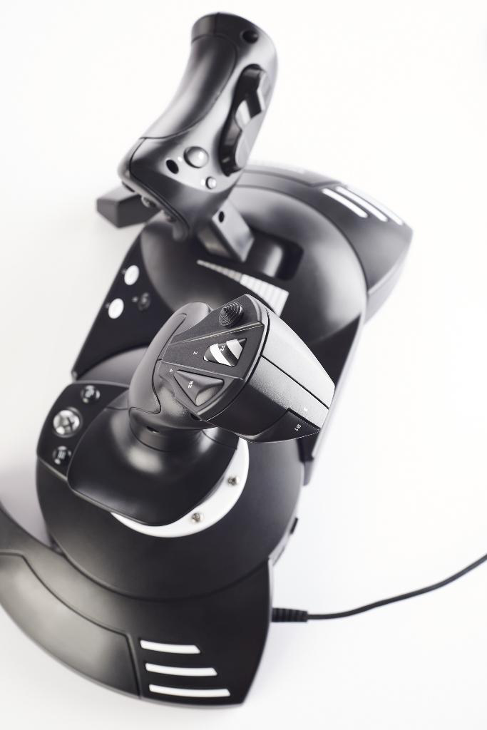 Een zwarte joystick en bedieningselementen voor een vluchtsimulator op een wit oppervlak.