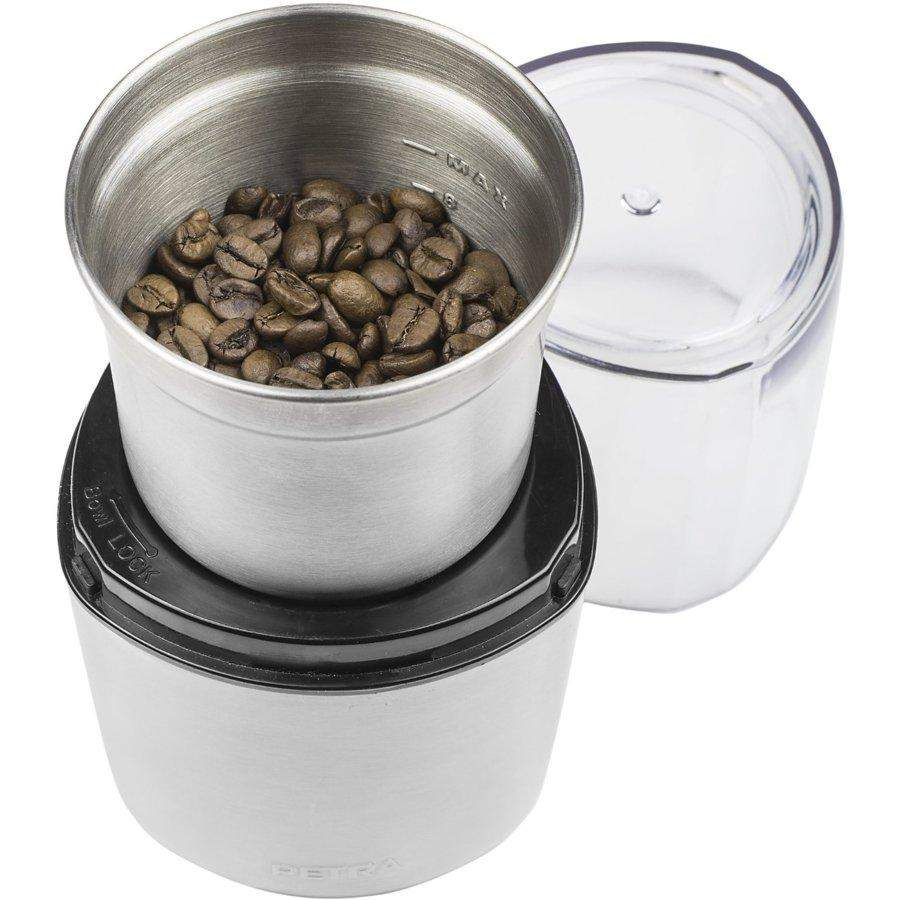 Coffee grinder with coffee beans inside. The grinder is silver, and the beans are brown.