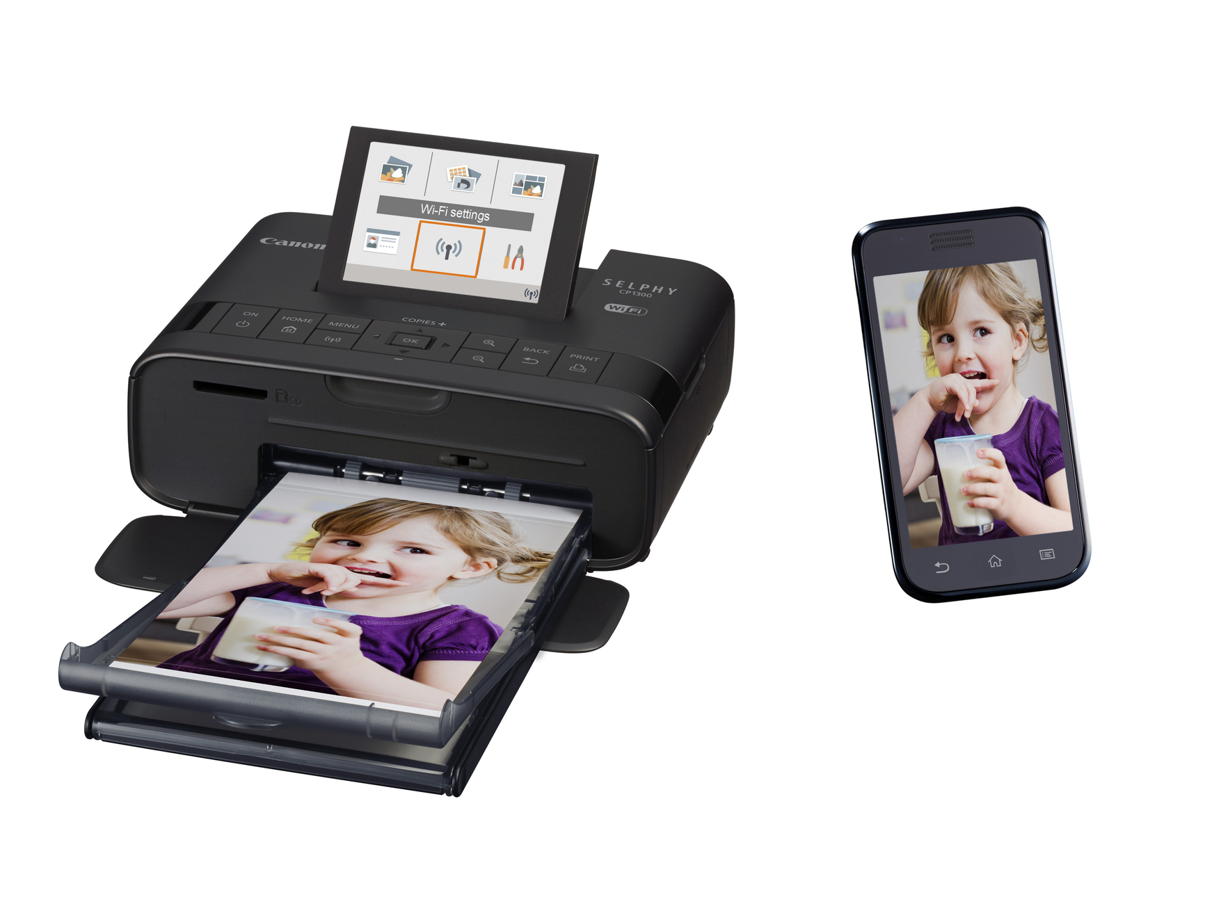 A black Canon Selphy printer prints a photo of a girl, next to a smartphone showing the same photo.