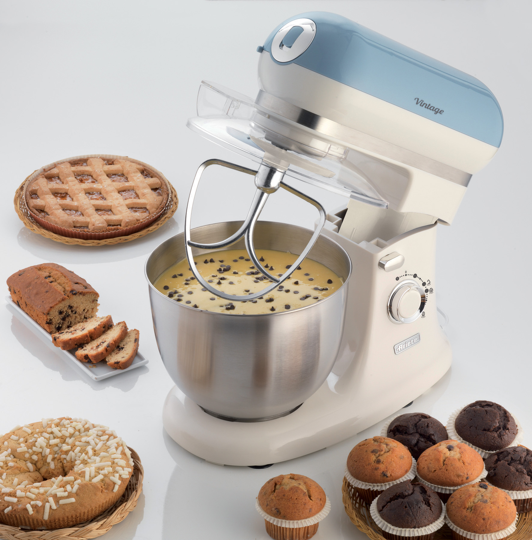 Un'impastatrice vintage con pasticcini e torte intorno.