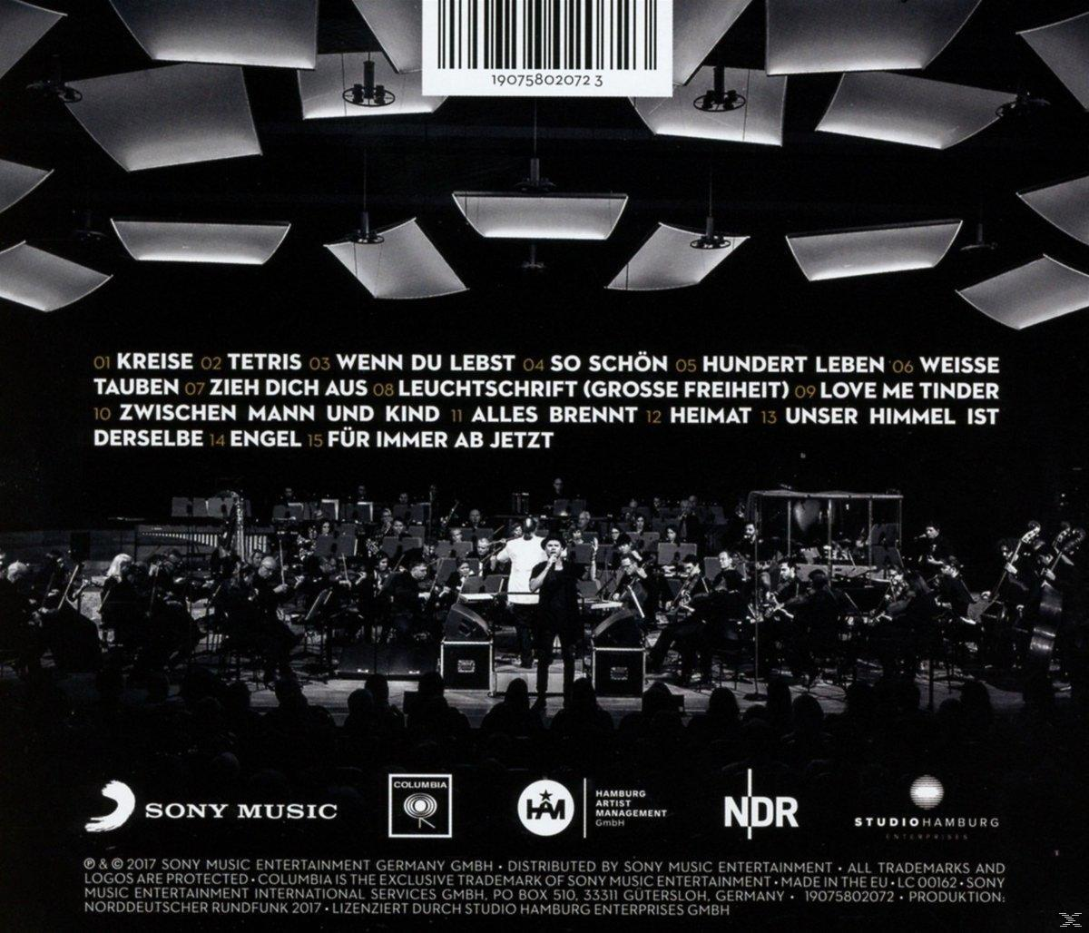 Rückseite eines Musikalbums mit Konzertfoto, Songtiteln und Logos auf dunklem Hintergrund.
