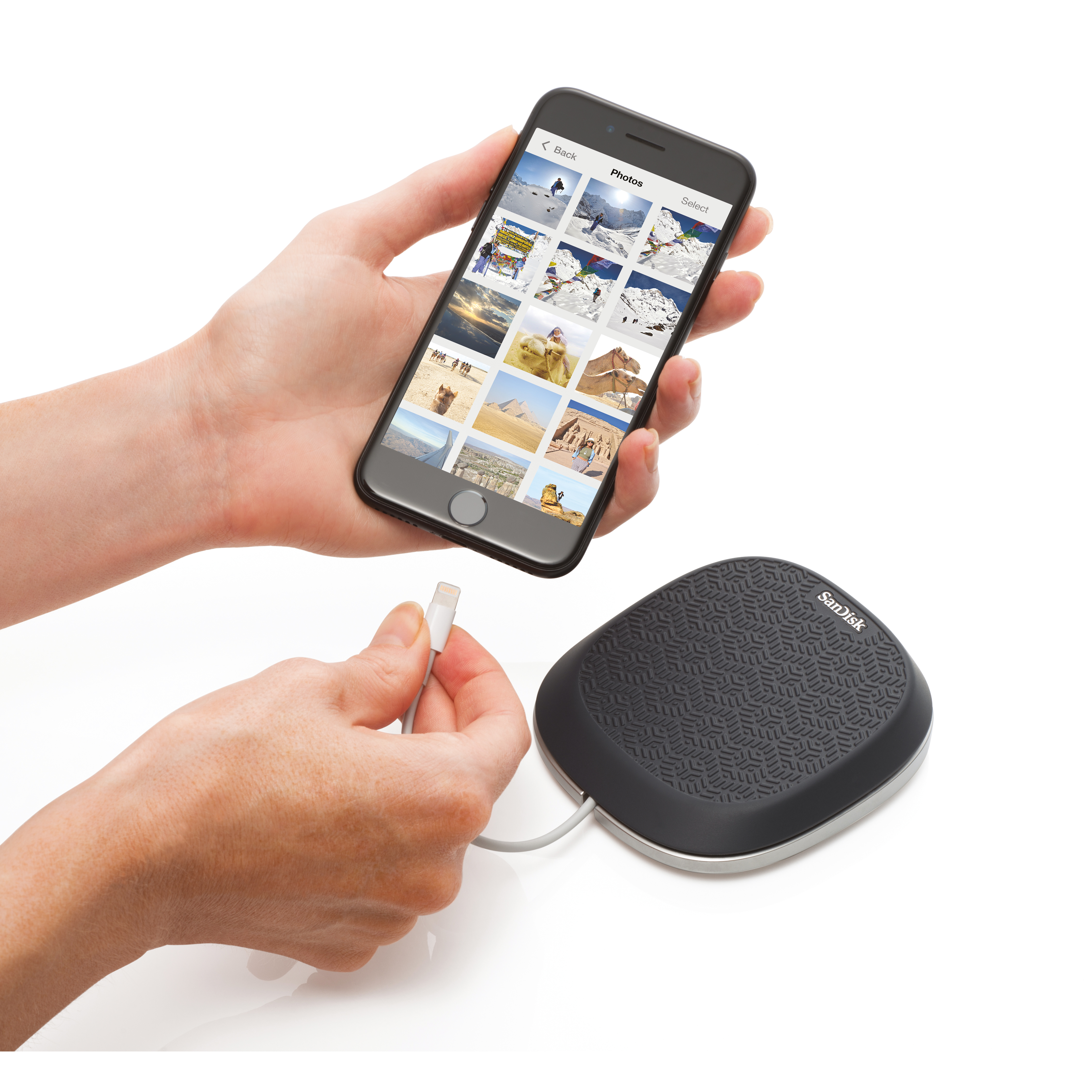 Person holding a phone displaying photos, connected to a SanDisk device.