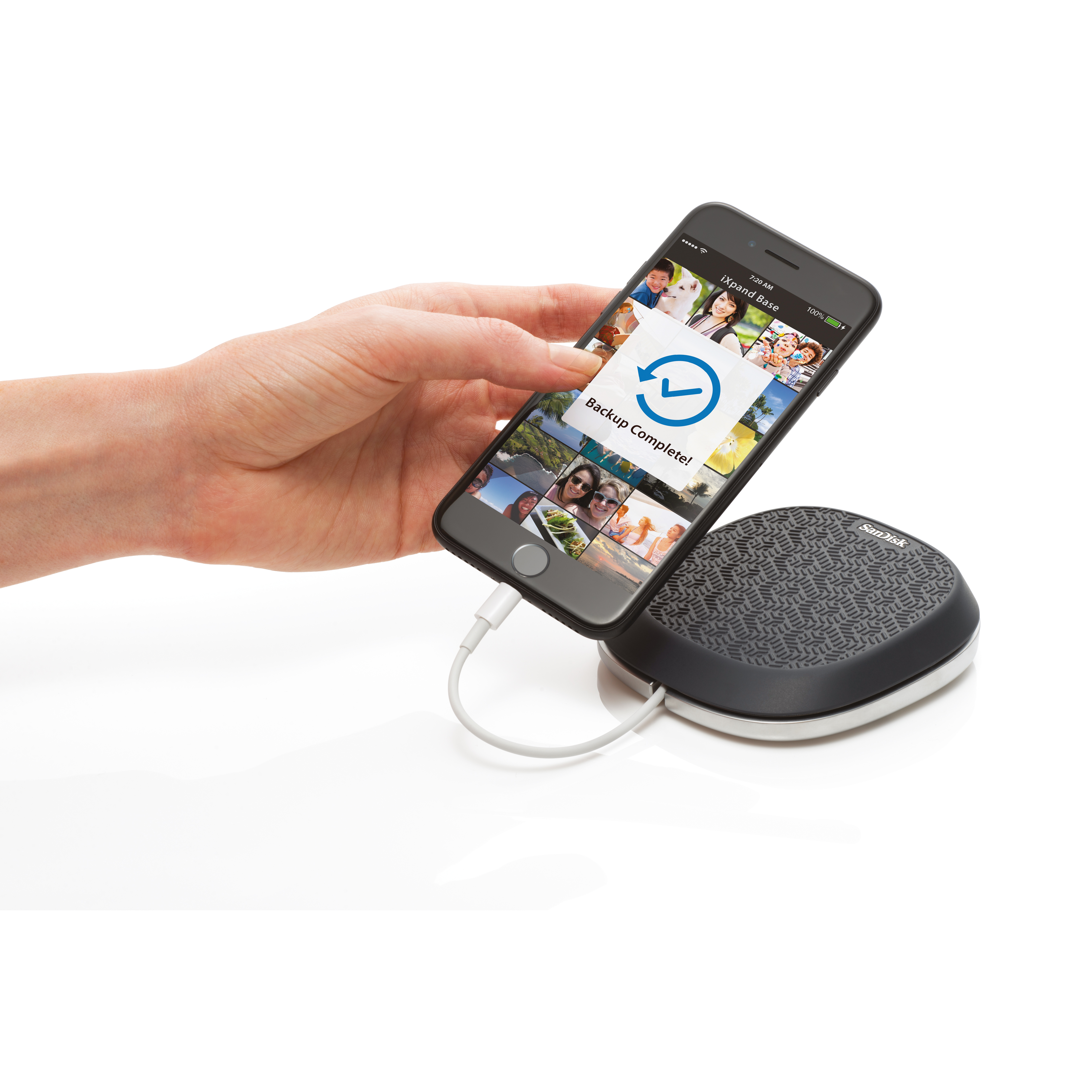A person holding a smartphone connected to a charging dock.