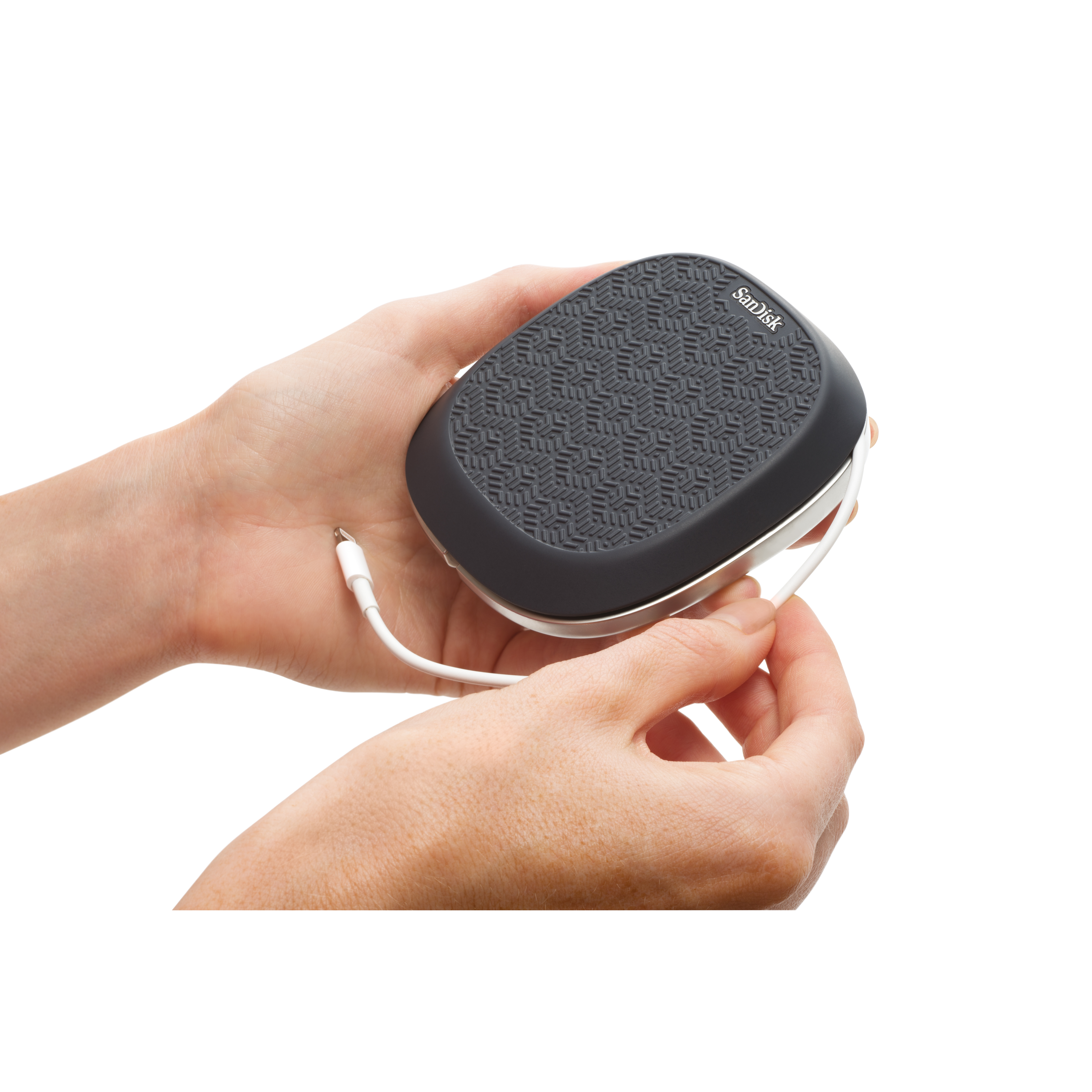Hands holding a black and gray SanDisk portable charger with a white cable against a white background.