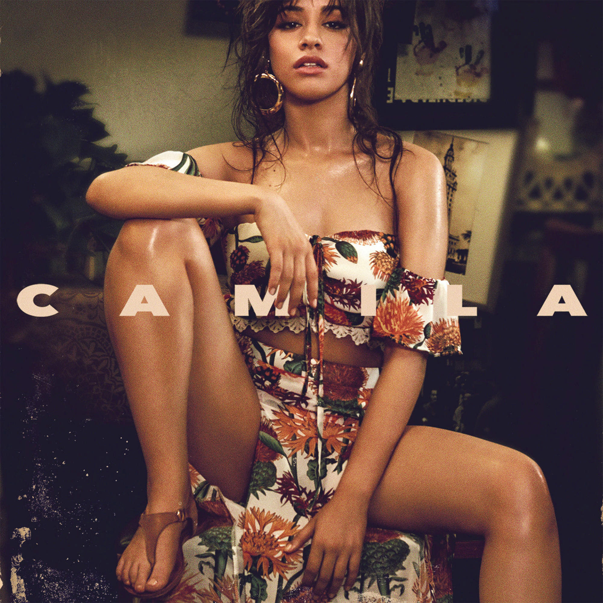 Camila Albumcover. Frau sitzt mit floralem Outfit. Das Wort 'Camila' in großen Buchstaben.