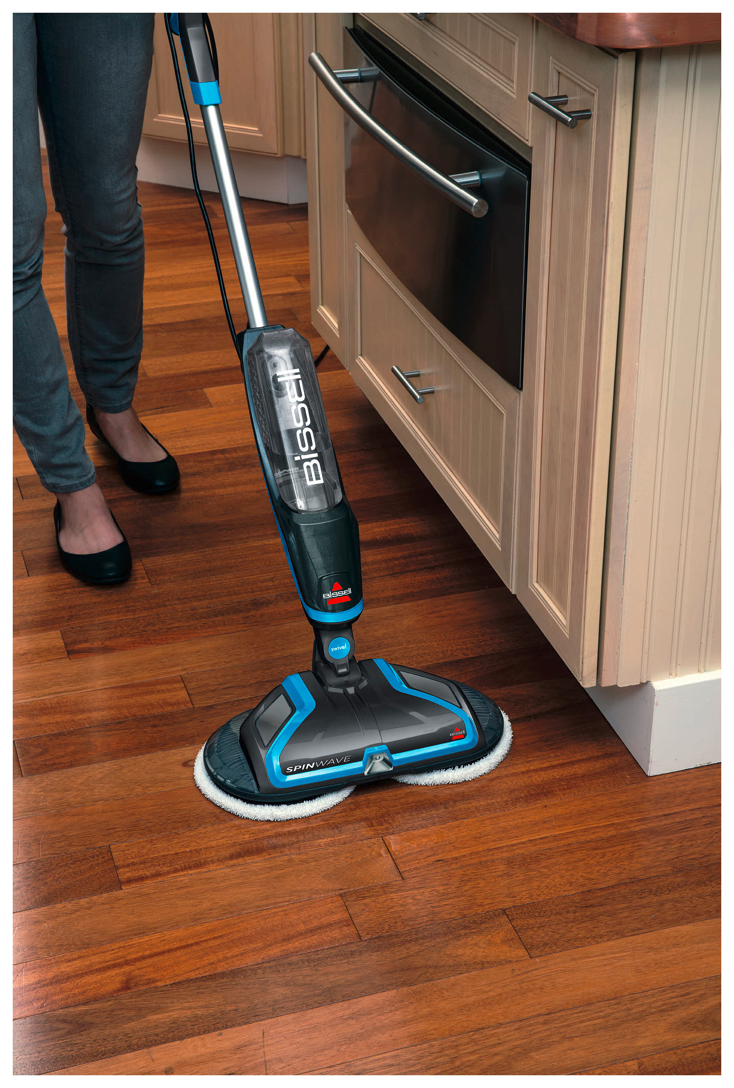 Eine Person reinigt einen Holzboden mit einem Bissell Spinwave Wischmopp.