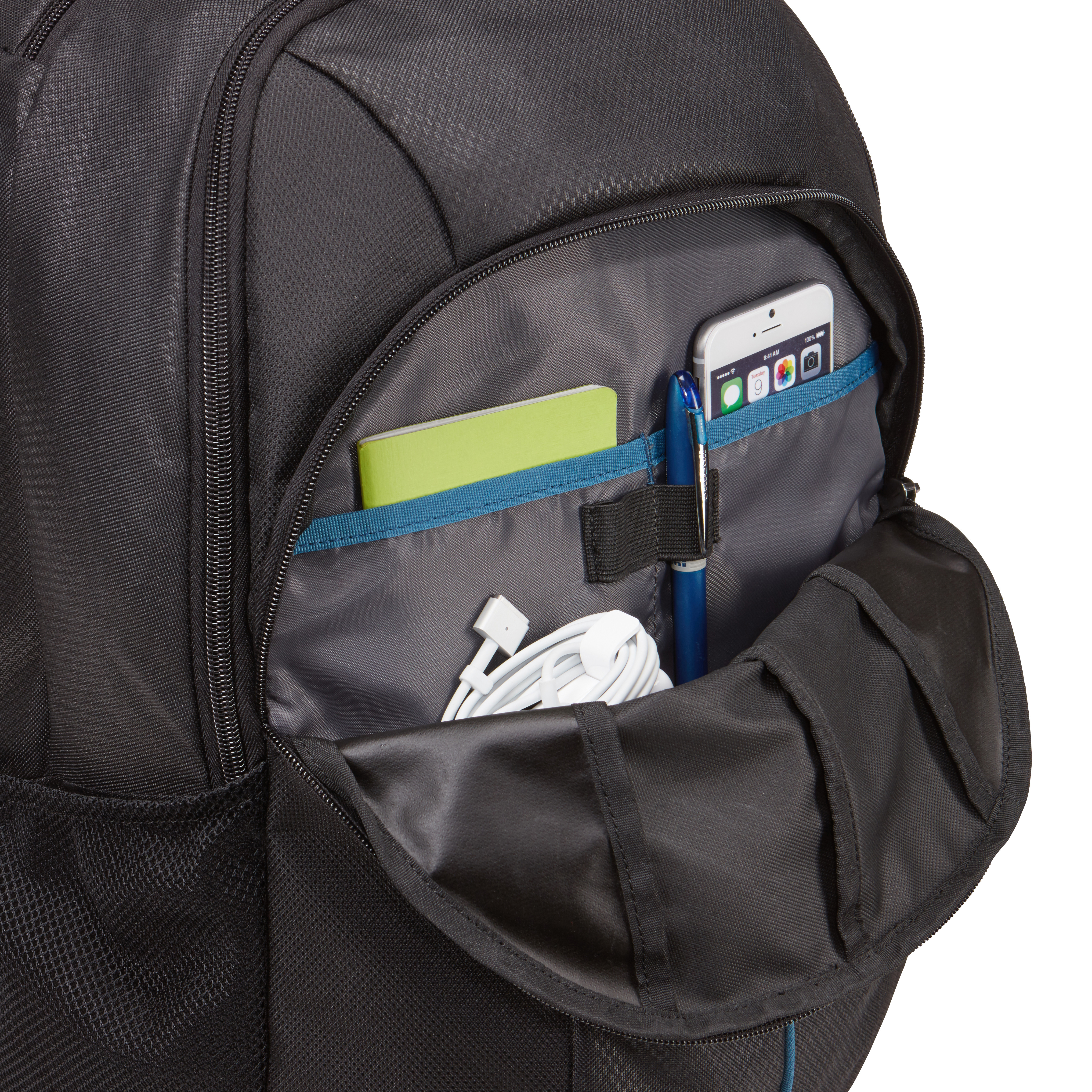 Sac à dos noir avec poche partiellement ouverte. Carnet, téléphone et stylo à l'intérieur.
