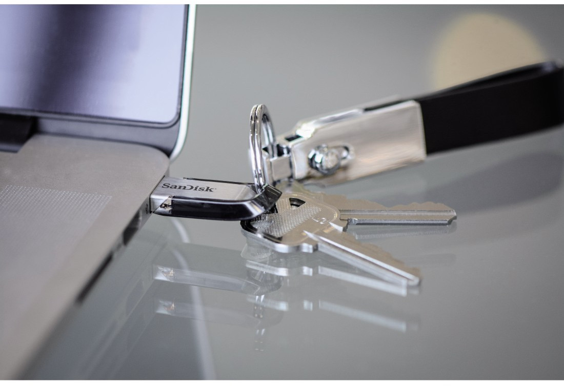 Clé USB, clés et porte-clés à côté d'un ordinateur portable.