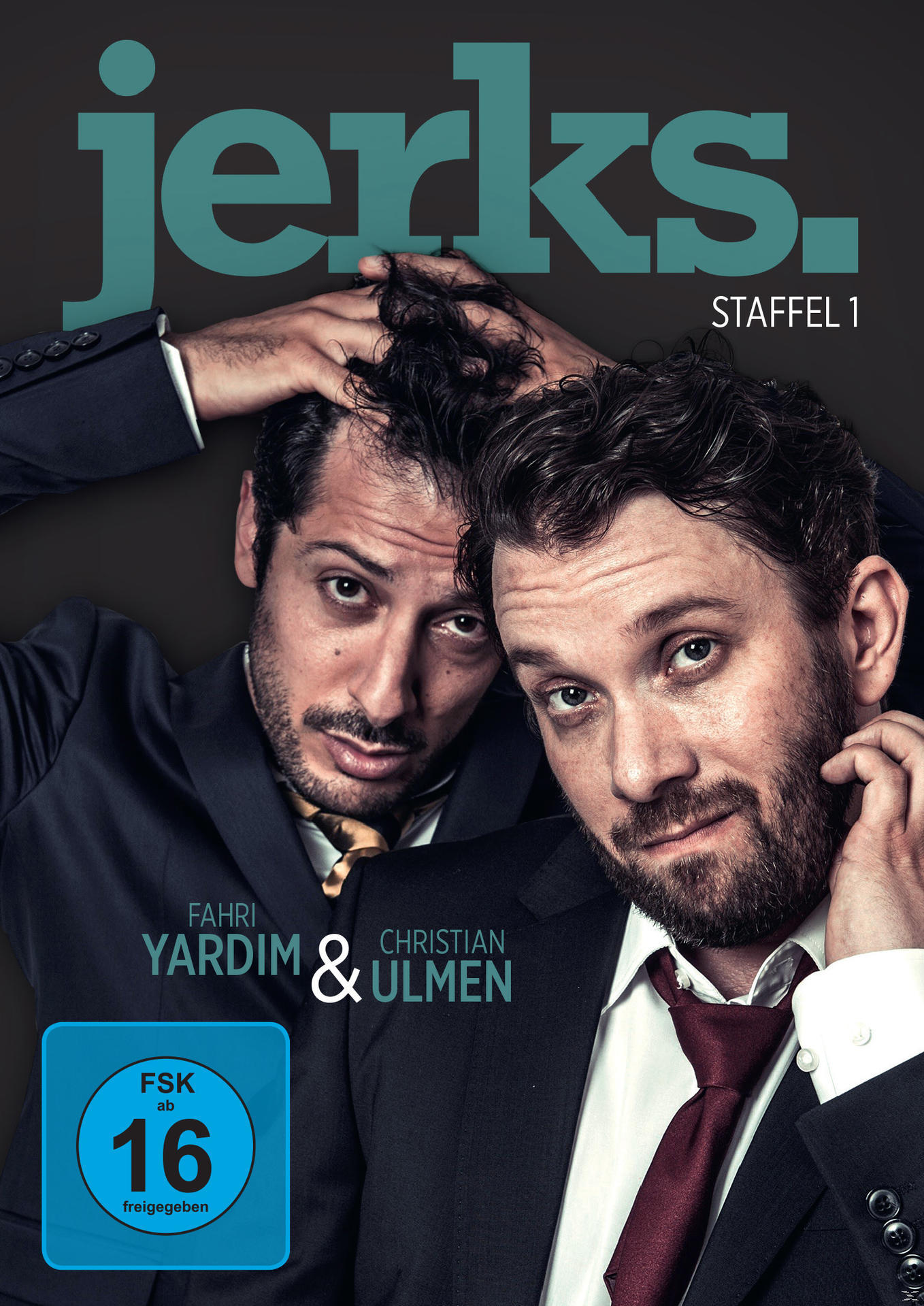 DVD-Cover mit zwei Männern in Anzügen, Titel 'jerks' und Bewertung '16'. Dunkler Hintergrund.