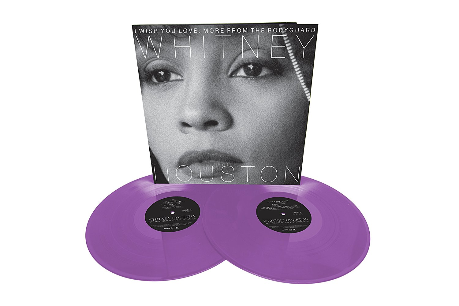 Zwei lila Vinylplatten mit einem Whitney Houston Albumcover im Vordergrund.