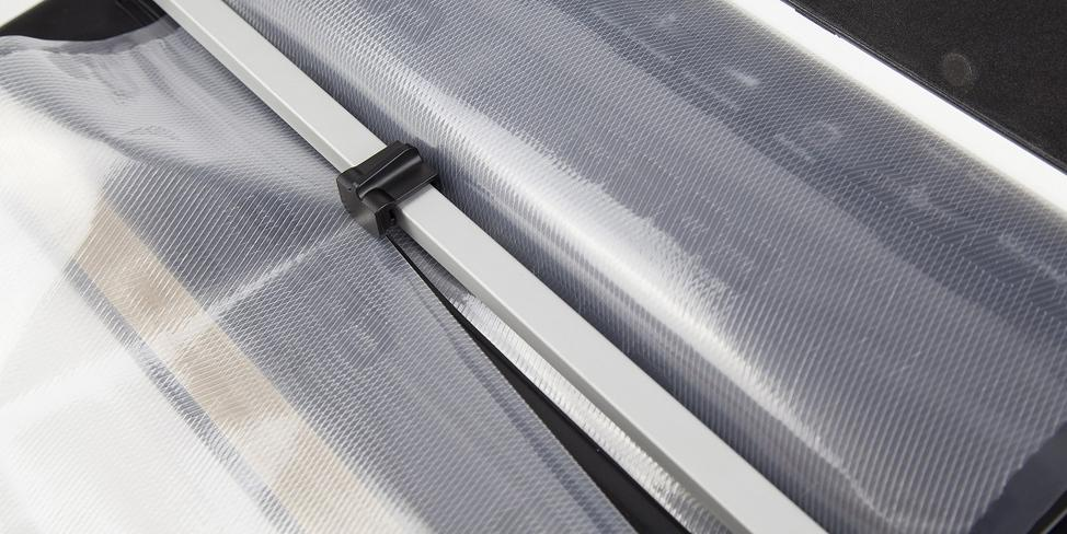 Nahaufnahme eines Vakuumversieglers mit Plastiktüten und einem silbernen Balken.
