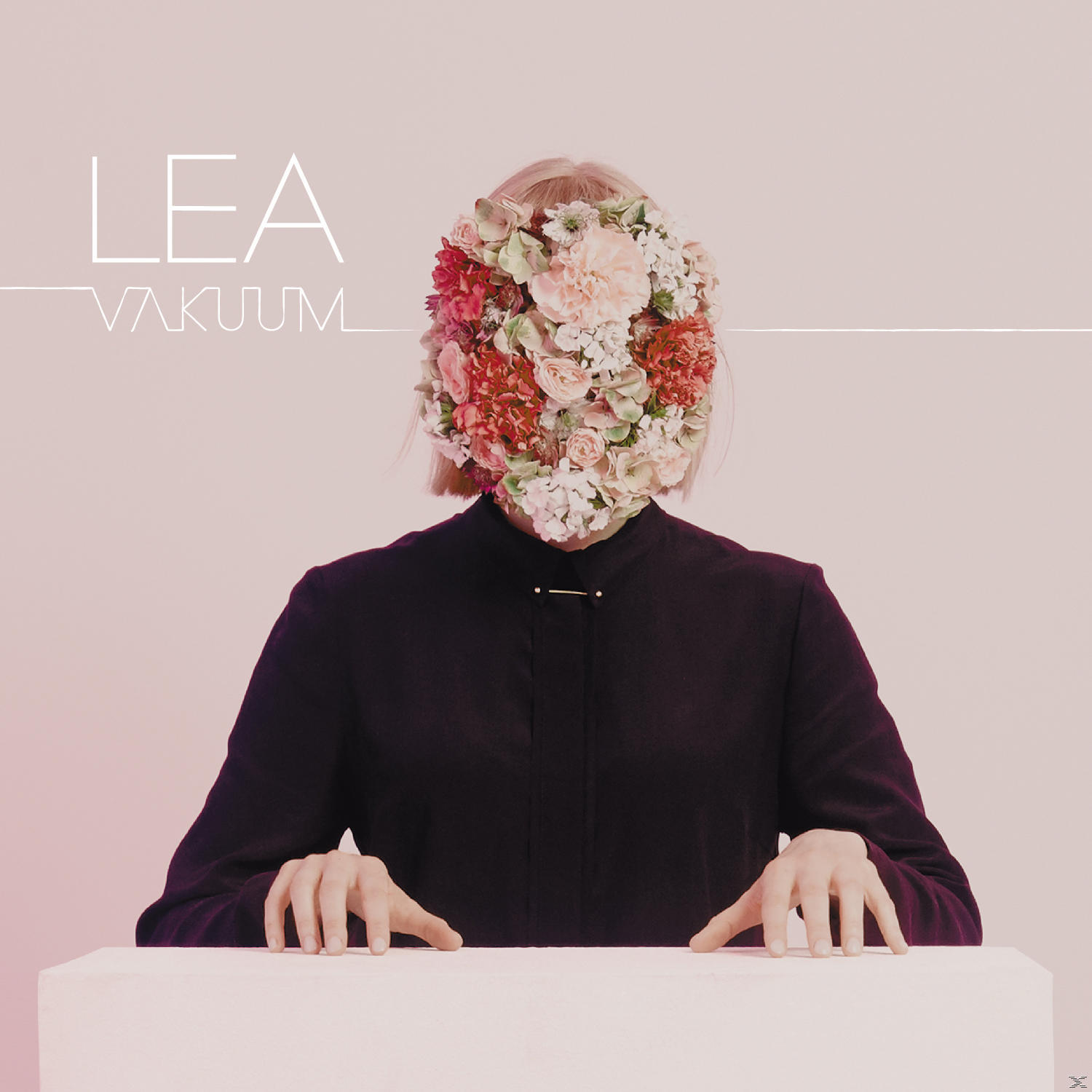 Albumcover: Eine Person mit blumenbedecktem Gesicht, schwarzem Hemd, weißem Tisch.