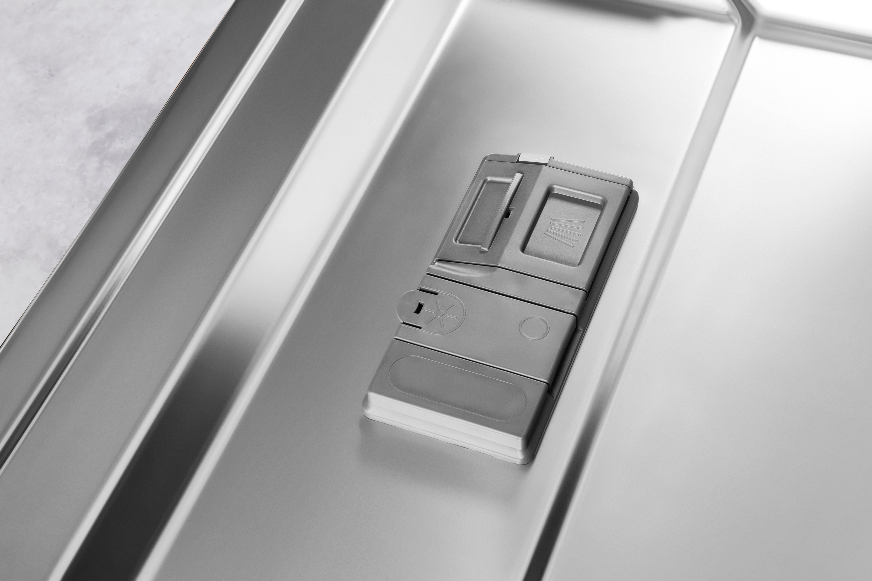 Dishwasher detergent dispenser in a stainless steel dishwasher.