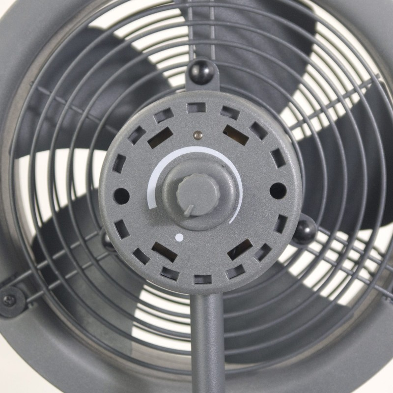 Gros plan sur un ventilateur gris. Le ventilateur a un design circulaire avec des pales et un cadran de contrôle. Le fond est blanc.