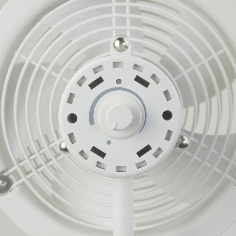 Gros plan d'un ventilateur électrique blanc. Il a une grille circulaire, un panneau de commande avec un bouton et un support. Le ventilateur est propre.