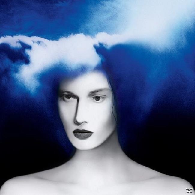 Porträt einer Frau mit blauem Wolkenhaar. Dunkelblauer Hintergrund. Blasse Haut und dunkelroter Lippenstift.
