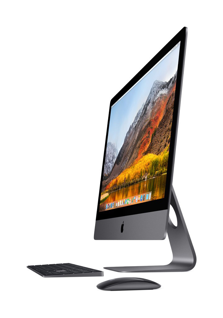 Ein Apple iMac Computer mit Tastatur und Maus. Der Bildschirm zeigt eine Landschaft mit Bergen.