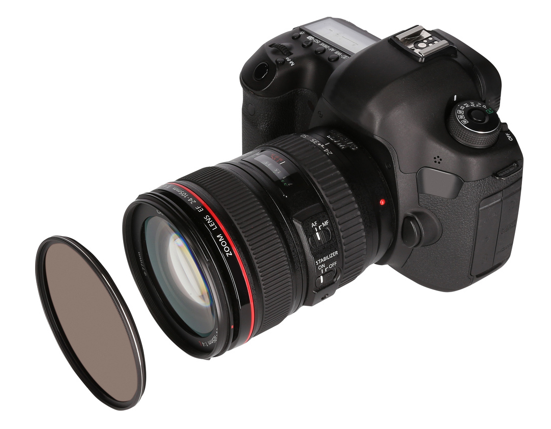A black DSLR camera with a lens and a filter is isolated on a white background. The lens is black, with red accents.