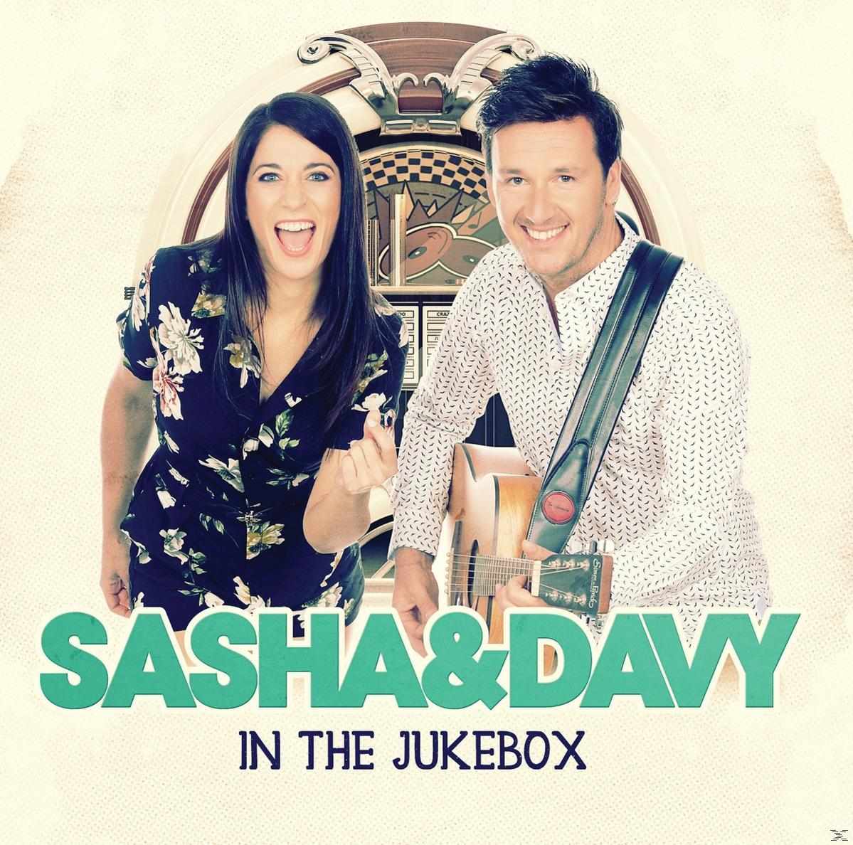 Pochette de l'album de Sasha & Davy. Un homme et une femme posent avec une guitare devant un juke-box.