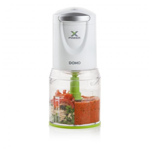 Robot culinaire blanc et transparent avec une lame verte et de la nourriture à l'intérieur.
