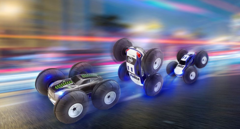 Spielzeugautos in Bewegung, mit verschwommenem Hintergrund aus Lichtern, drei Spielzeugautos in verschiedenen Positionen.