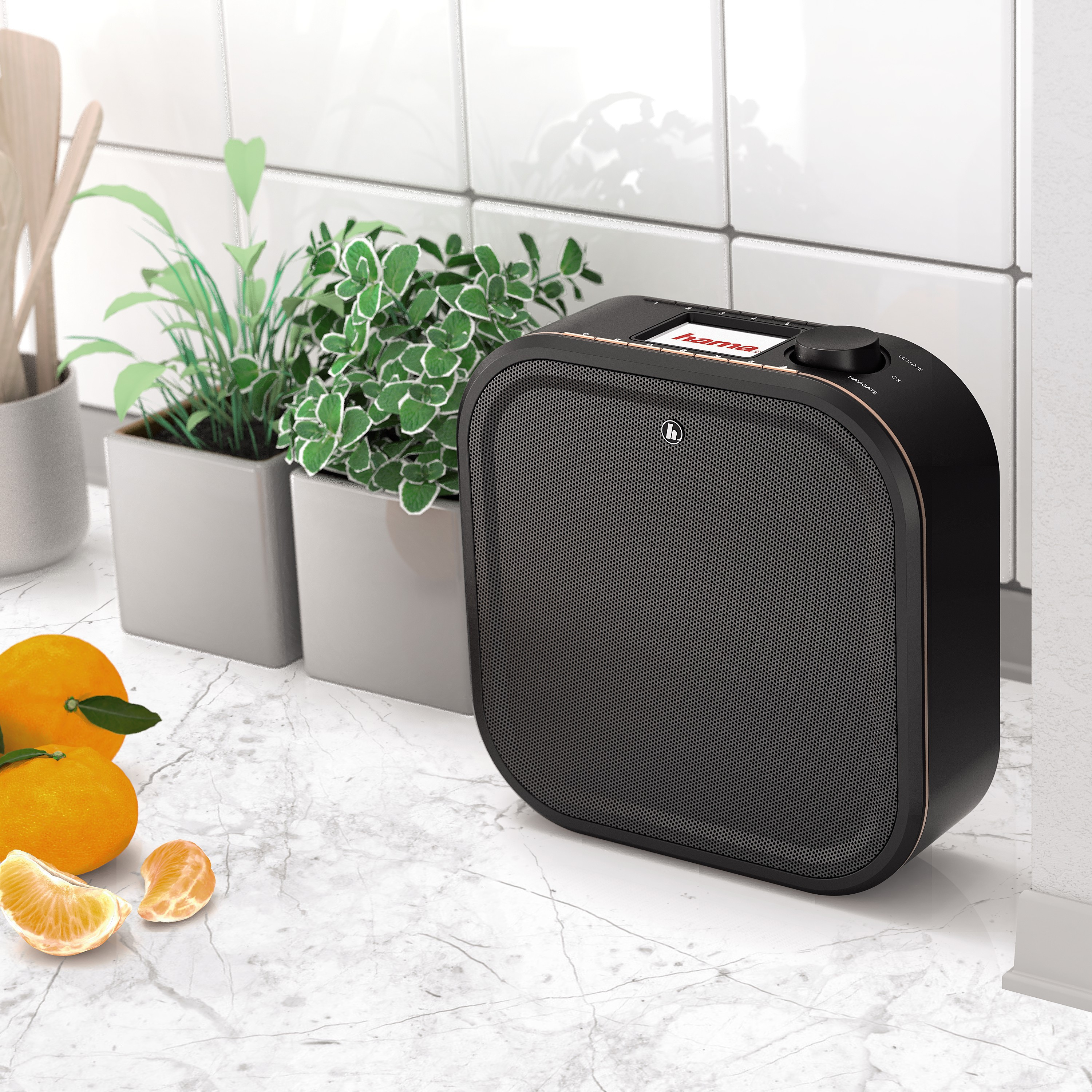 Schwarzes und goldenes Radio auf Marmortisch, mit Pflanzen und Orangen.