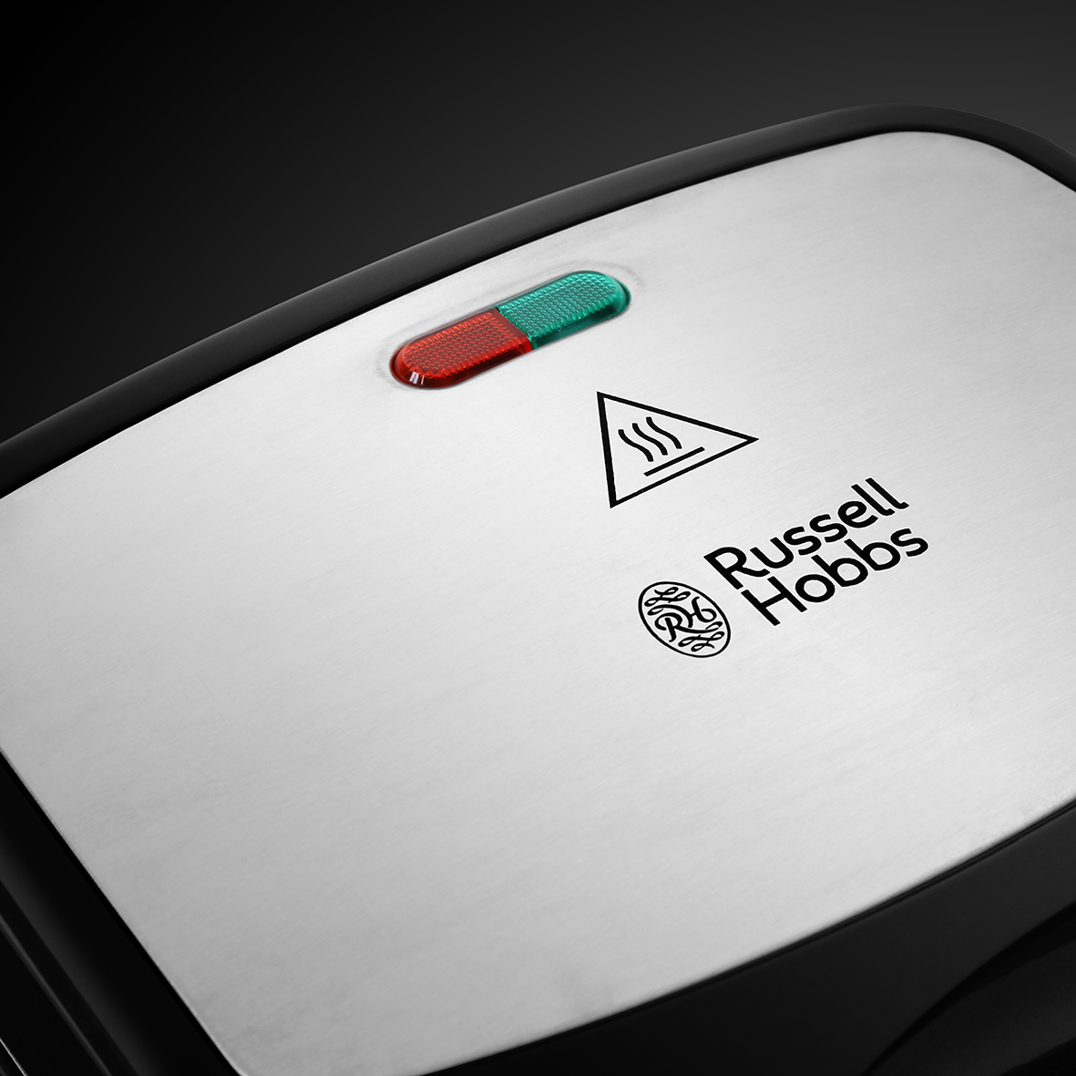 Sandwich-Toaster-Oberseite. Rote und grüne Lichter, Russell Hobbs Logo, Warnschild.