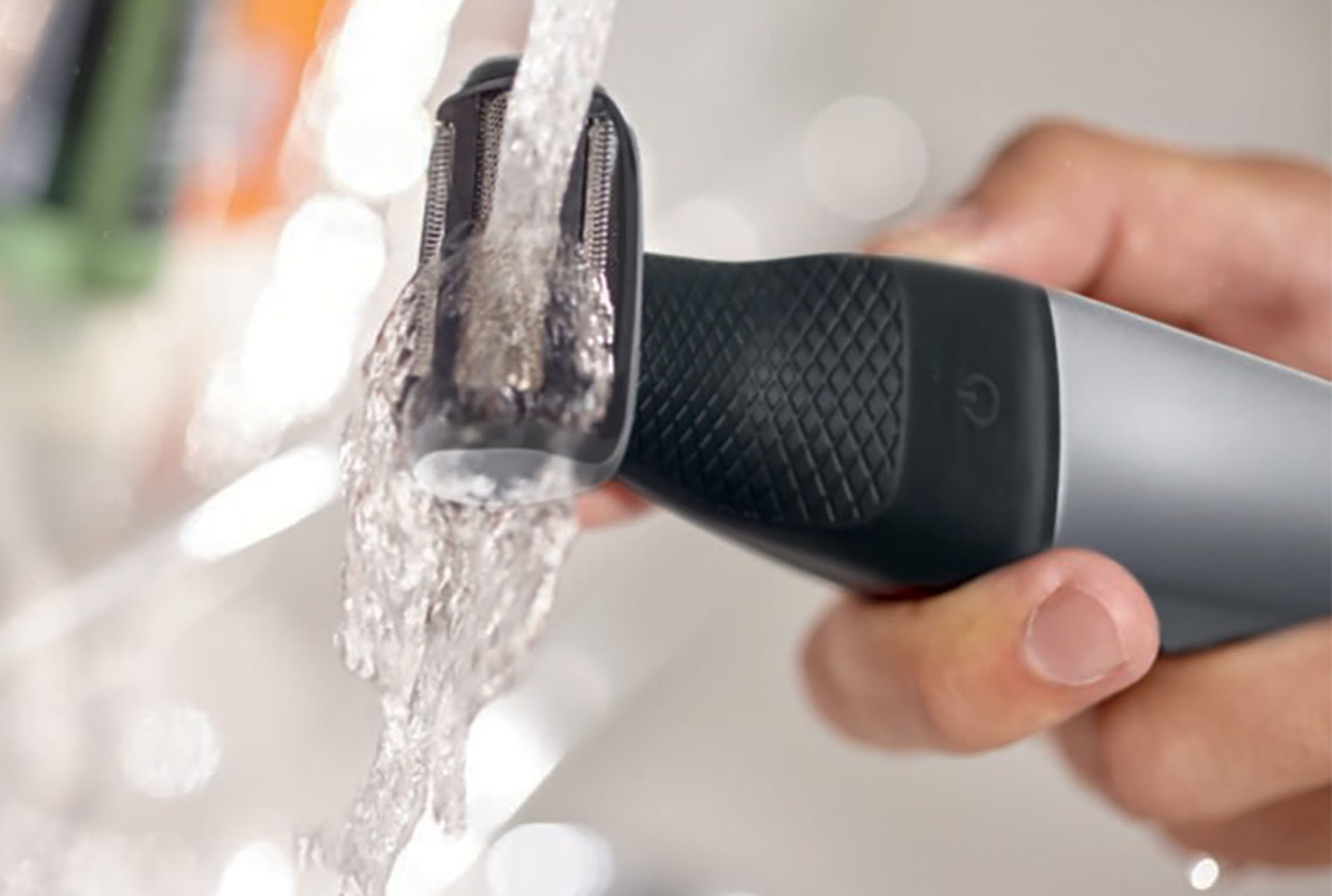 Outil de toilettage sous l'eau courante, mains le tenant.