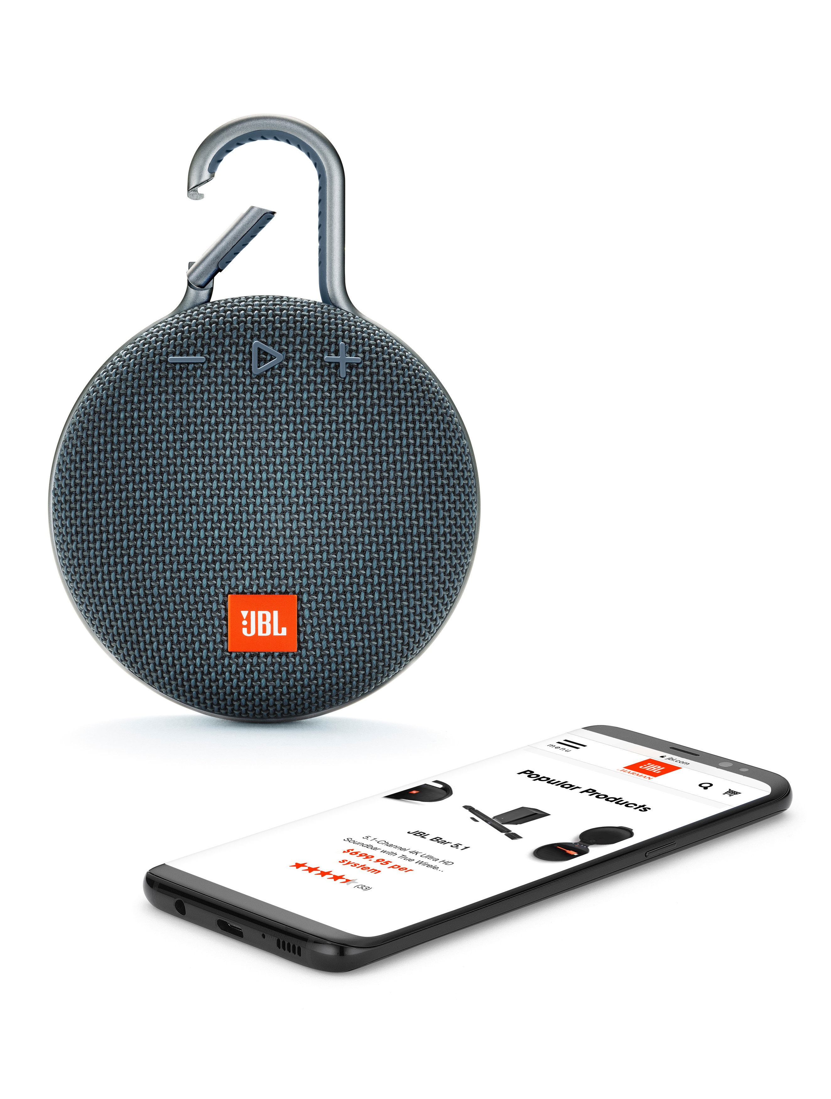 Tragbarer JBL Clip 3 Lautsprecher mit einem Telefon, das eine Produktseite zeigt. Der Lautsprecher ist dunkelblau.