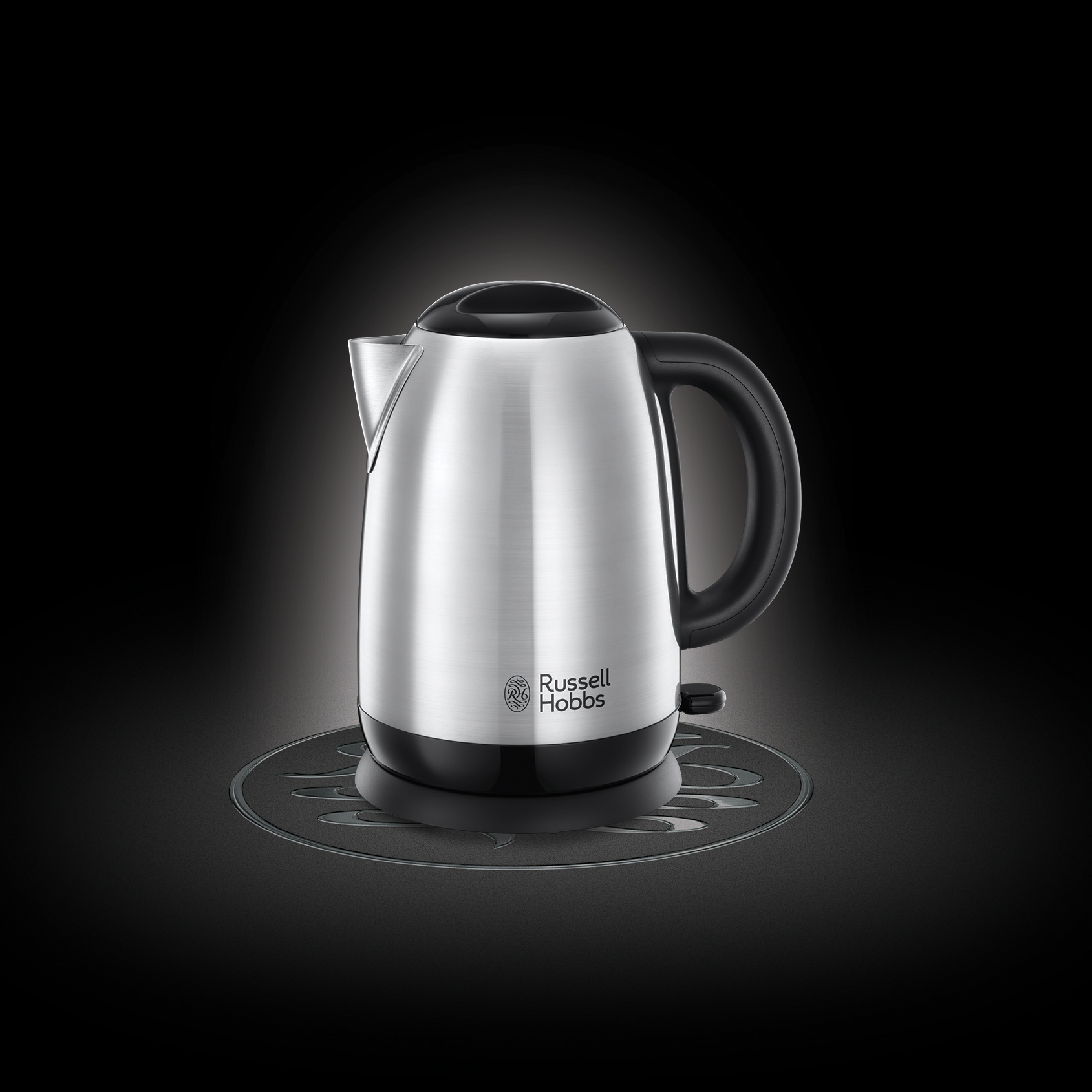Egy ezüst Russell Hobbs elektromos vízforraló fekete alapon. A háttér fekete.