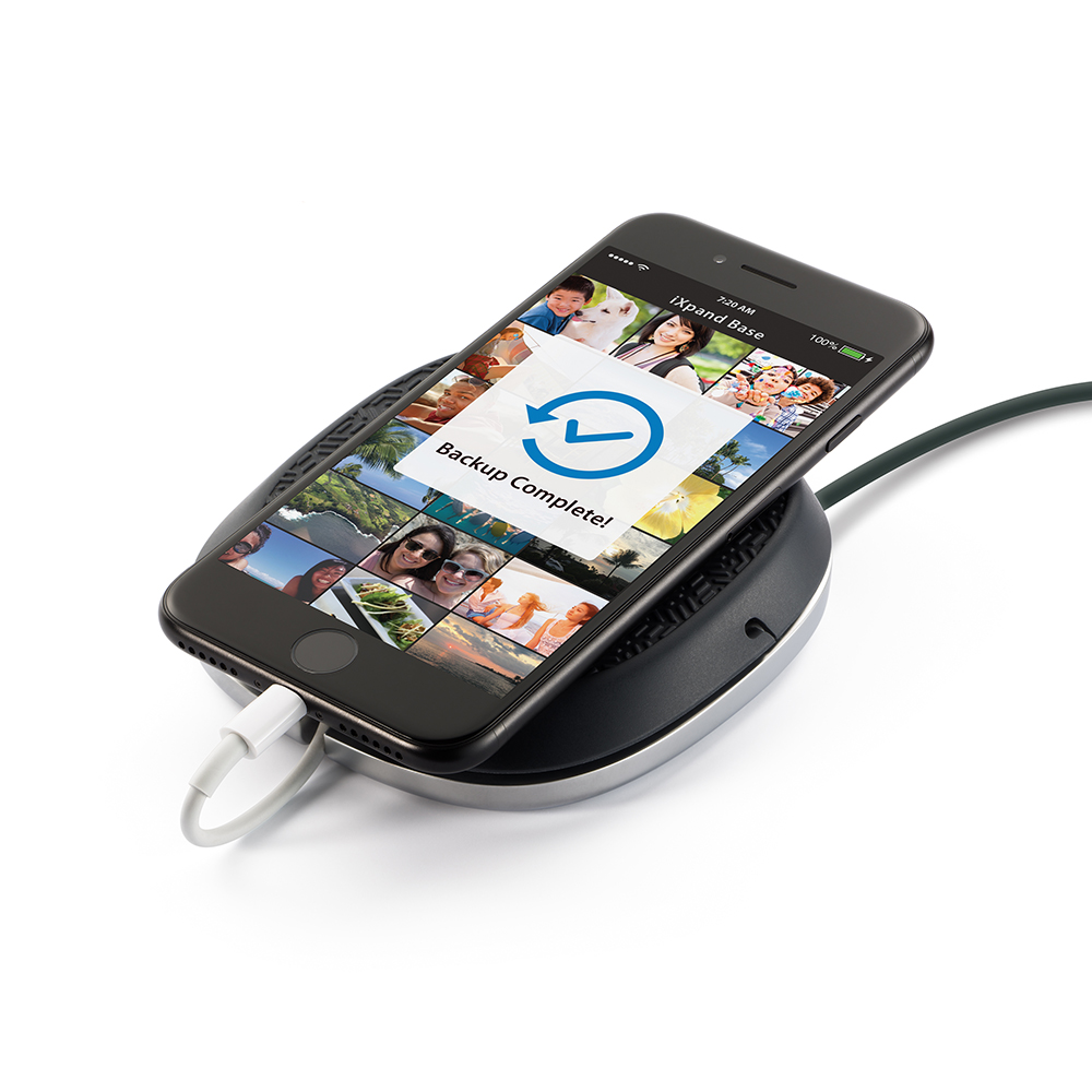 A phone on a charging base, showing a backup complete notification.