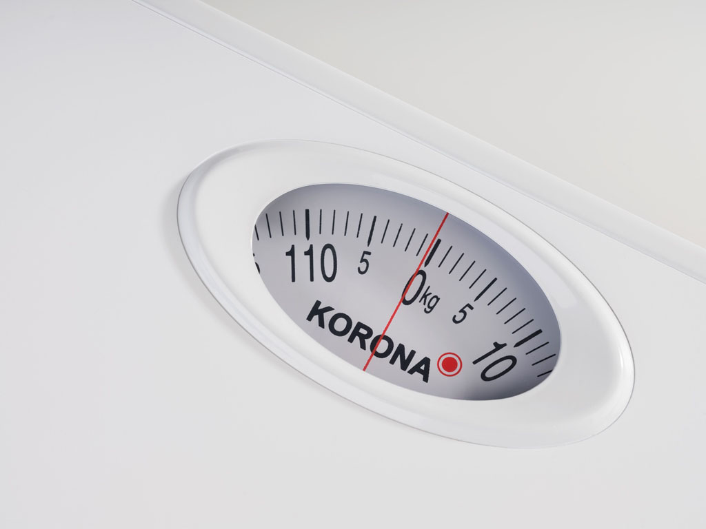 Nahaufnahme einer weißen Waage mit einer Anzeige von 5,0 kg, KORONA ist auf dem Zifferblatt aufgedruckt.