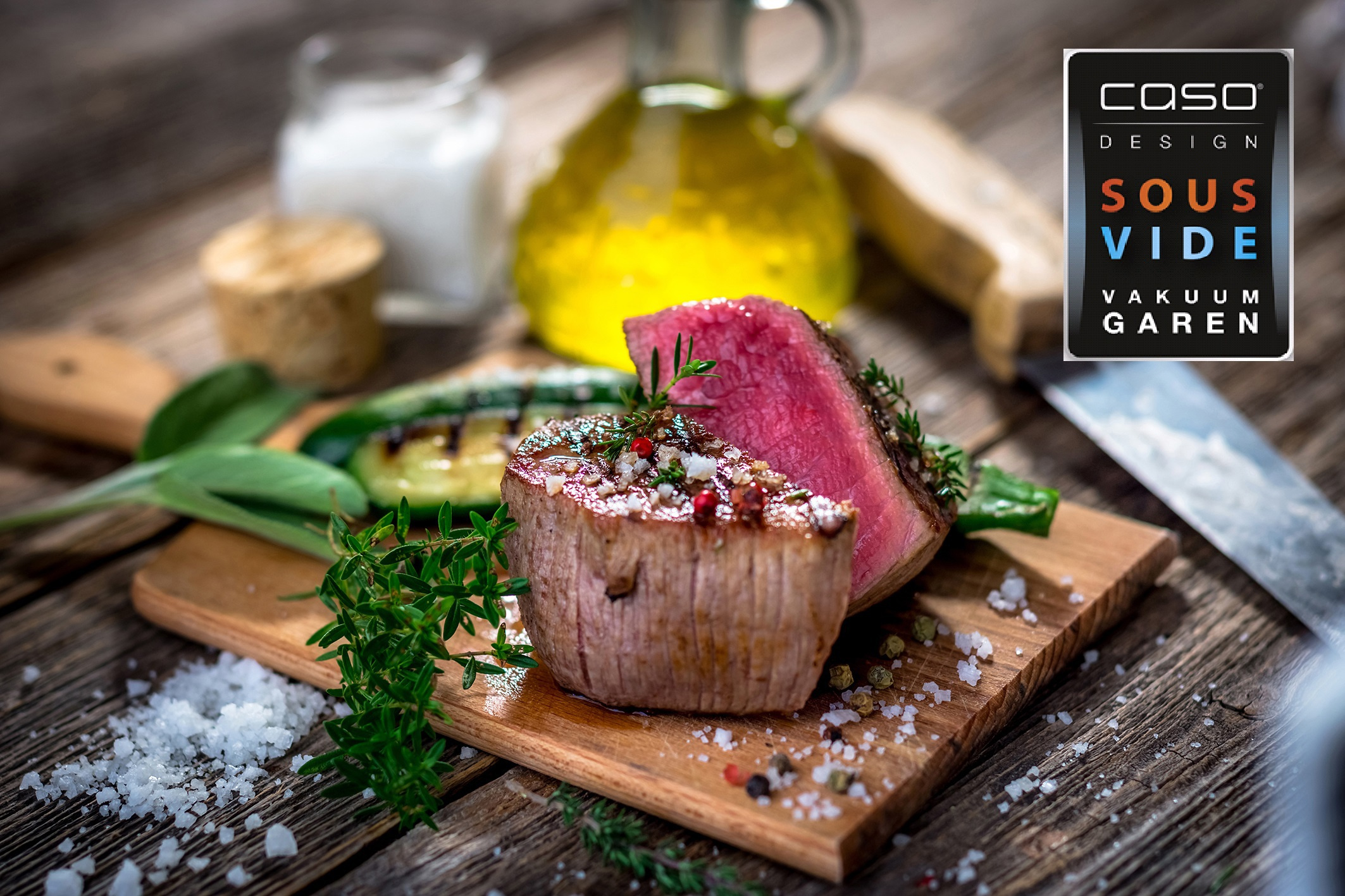 Geschnittenes Steak mit Kräutern und Gewürzen auf einem Holzbrett mit Ölflasche und Messer.