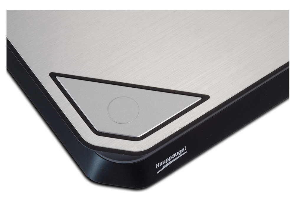 Close-up of a digital scale's corner with a silver button and black trim.