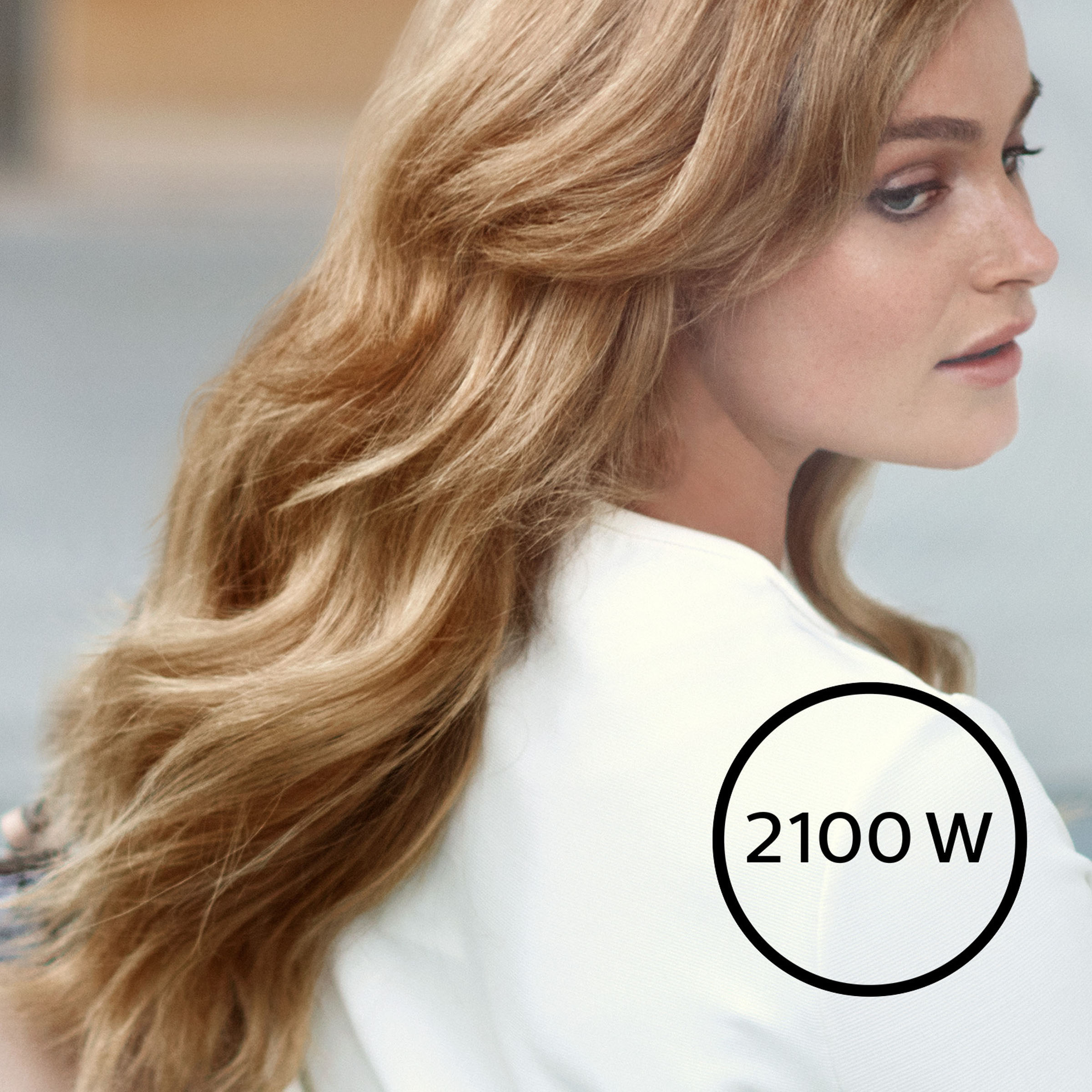 Frau mit blonden Haaren, weißem Hemd und einem schwarzen Kreis mit 2100W.