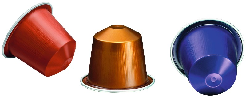 Tres cápsulas de café. Rojo, bronce y azul. Fondo blanco.
