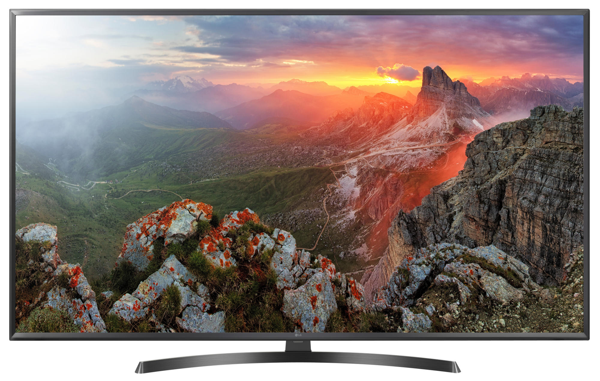 Un televisor LG grande que muestra un paisaje montañoso al atardecer. Primer plano rocoso.