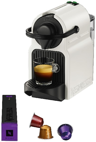 Witte Nespresso-machine met kopje koffie, drie capsules en een doosje capsules op een wit oppervlak.