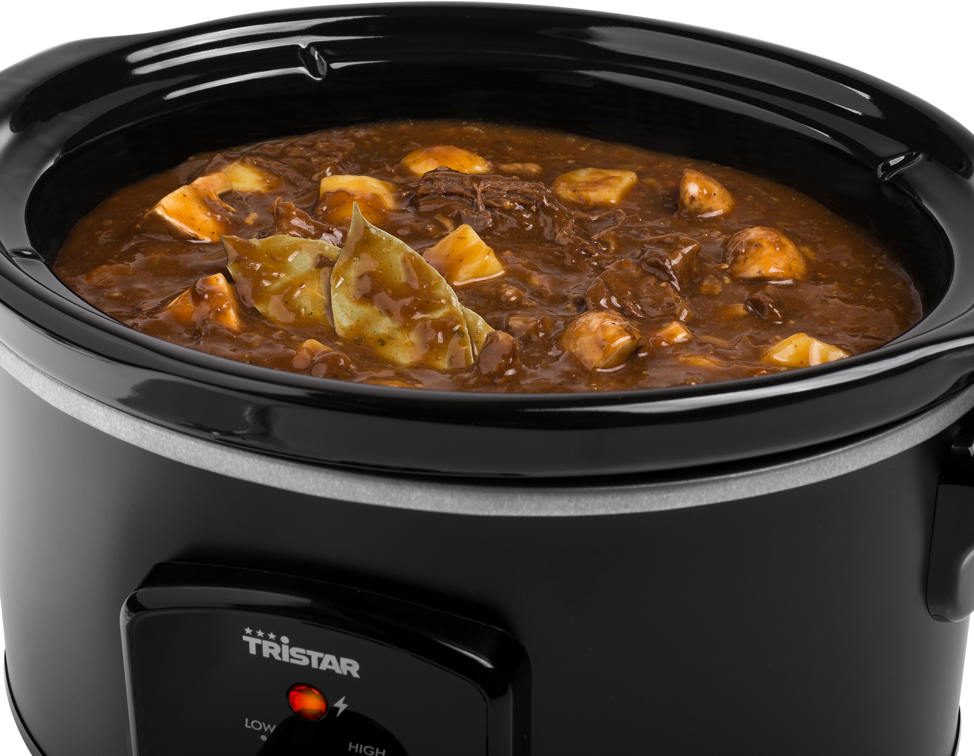 Close-up of a black slow cooker filled with stew, including meat and vegetables.