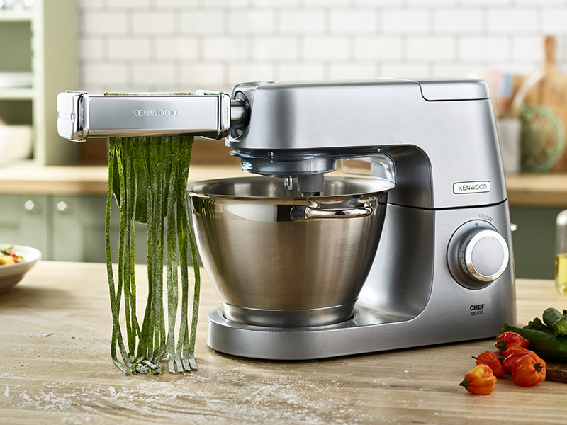Silberne Kenwood Chef Elite Küchenmaschine mit Pastamaker, der grüne Pasta herstellt.