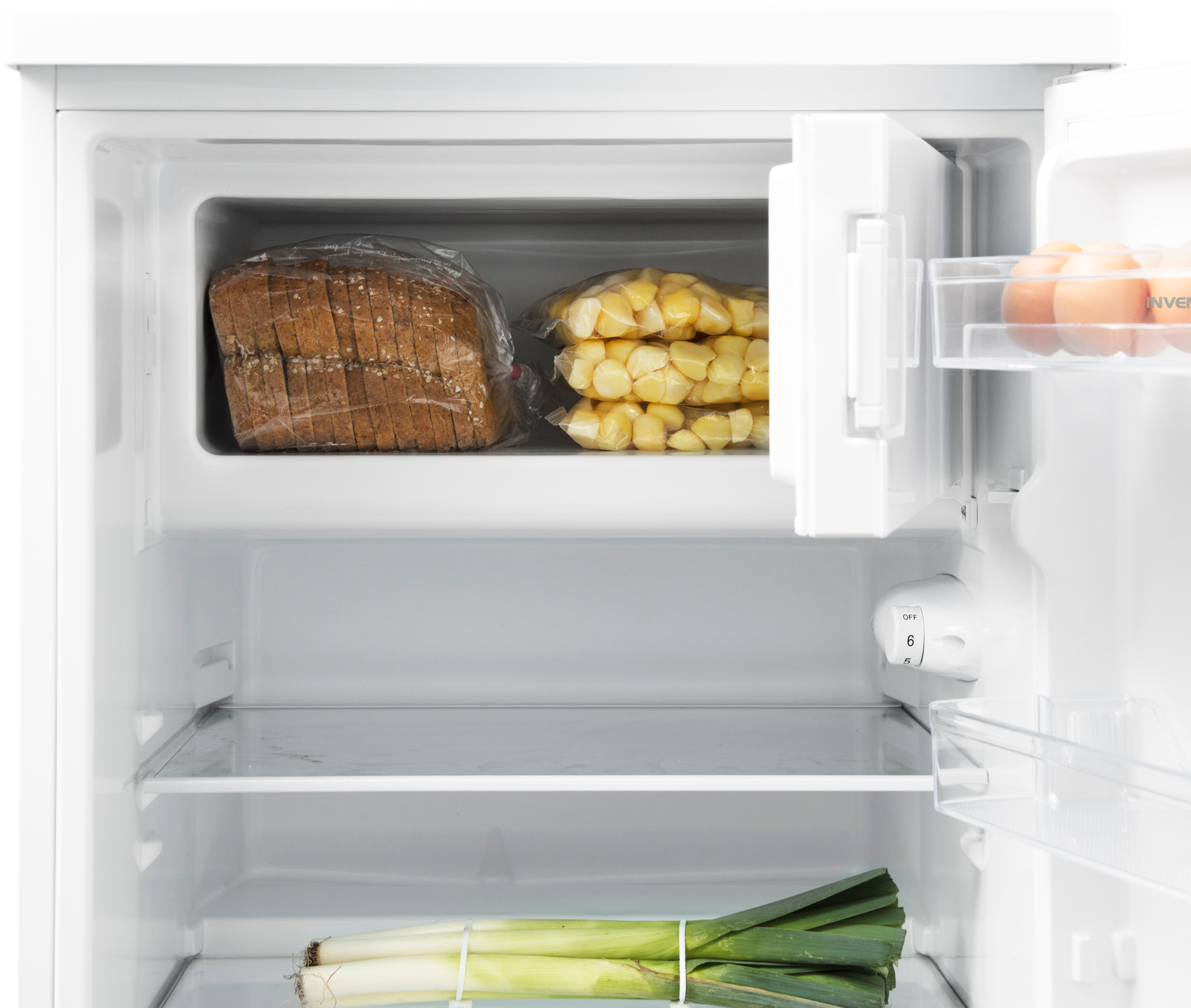 A refrigerator with bread, corn, eggs, and leeks inside.