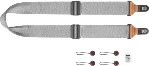 Grauer Kameragurt, schwarze und braune Details, sowie kleine schwarze und rote Verbinder.