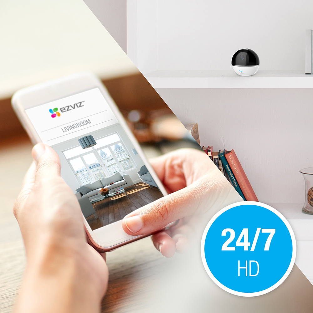 Een telefoon toont een woonkamer met een beveiligingscamera. Een camera en 24/7 HD-tekst staan in de afbeelding.
