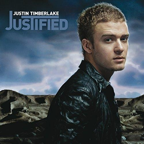Albumcover: Justin Timberlake, betitelt 'Justified'. Timberlake in schwarzer Jacke, blickt den Betrachter an, dunkler Himmel im Hintergrund.