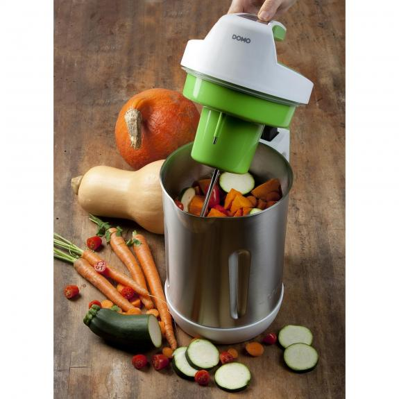 Un appareil de cuisine avec des légumes, dont des carottes et des courgettes, en cours de traitement.