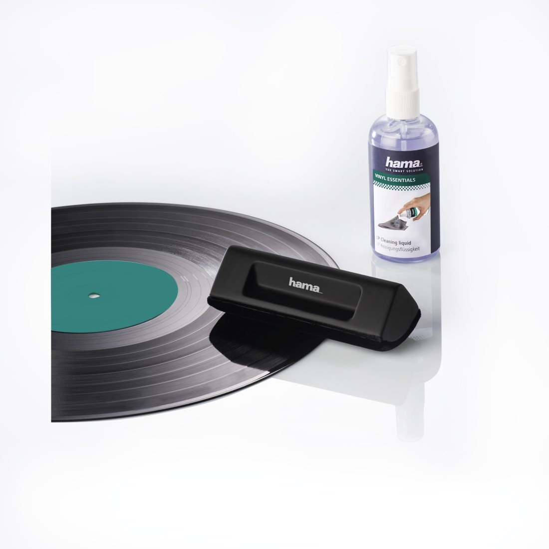 Disque vinyle, brosse de nettoyage et liquide de nettoyage sur une surface blanche. Surface réfléchissante.
