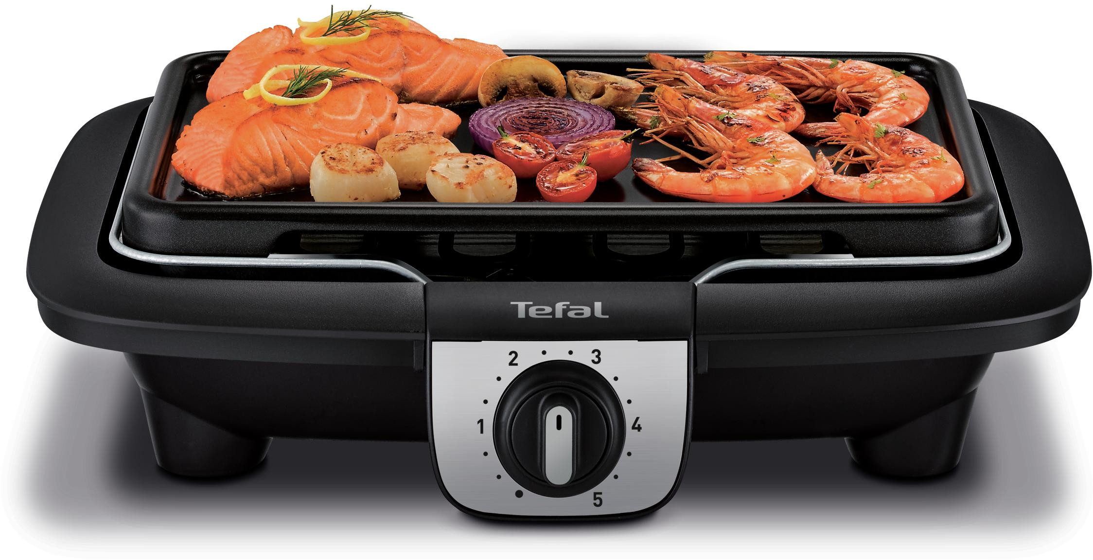 An electric grill with cooked seafood and vegetables, set to a temperature level.