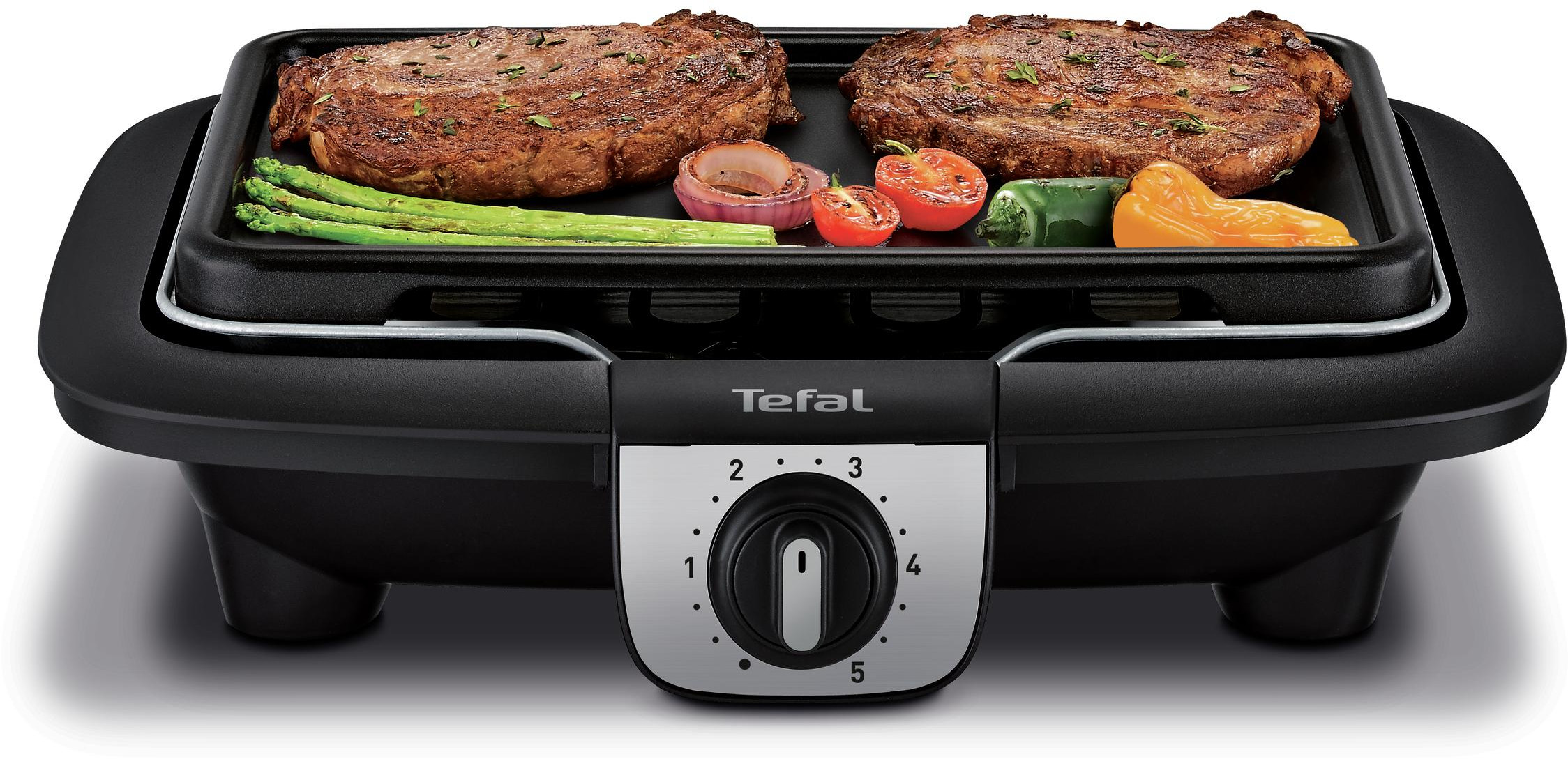 Tefal electric grill with two steaks, tomatoes, onions and asparagus. The grill is black.