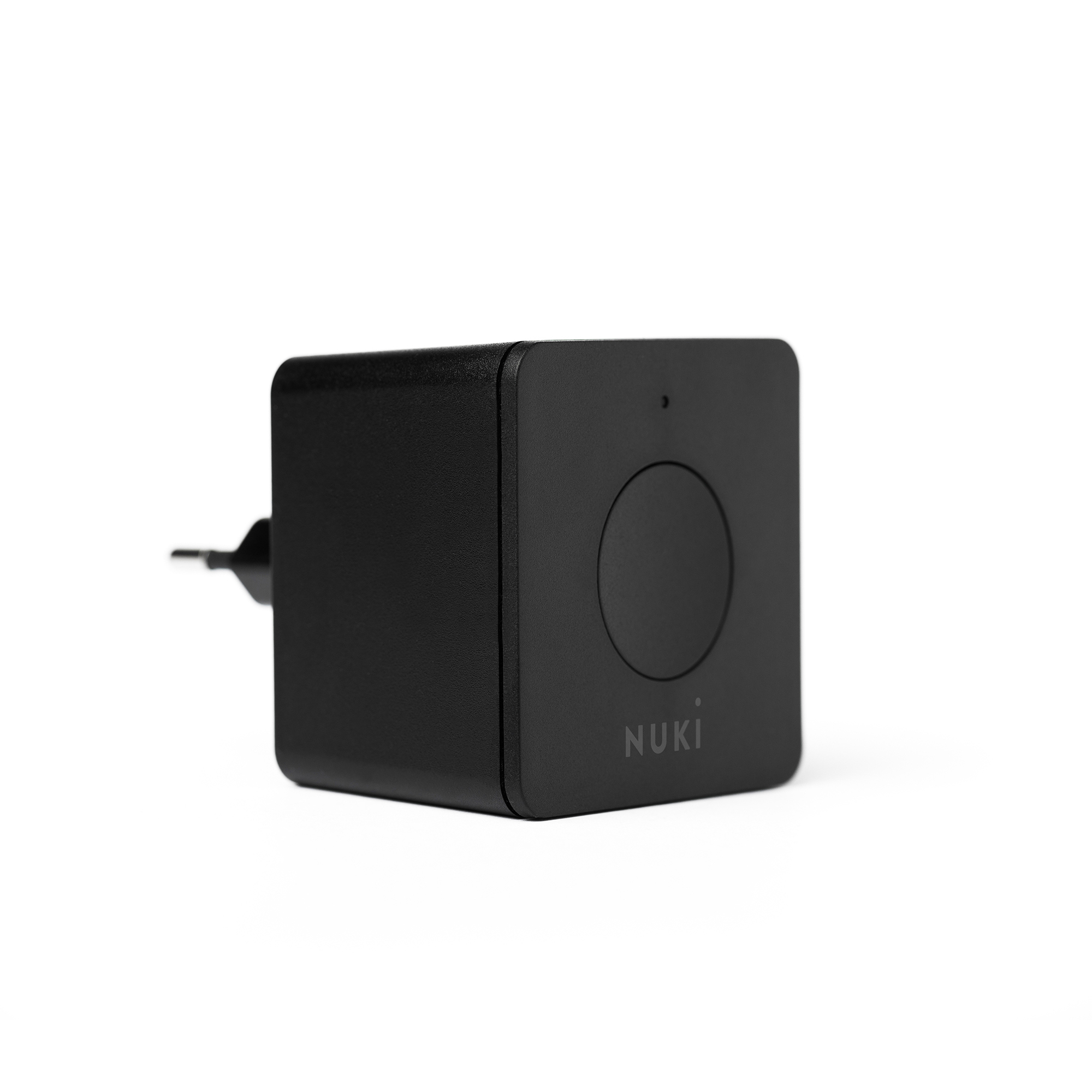 Ein schwarzes Nuki Smart-Home-Gerät auf weißem Hintergrund mit einem runden Knopf und Nuki-Logo.