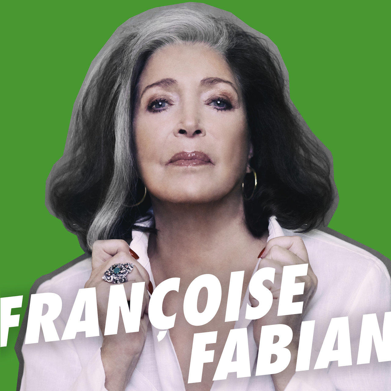 Françoise Fabian sur fond vert. Elle porte une chemise blanche, avec des cheveux gris.